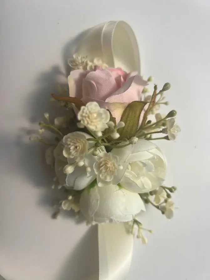 Floral corsage with pink and white flowers on a white background