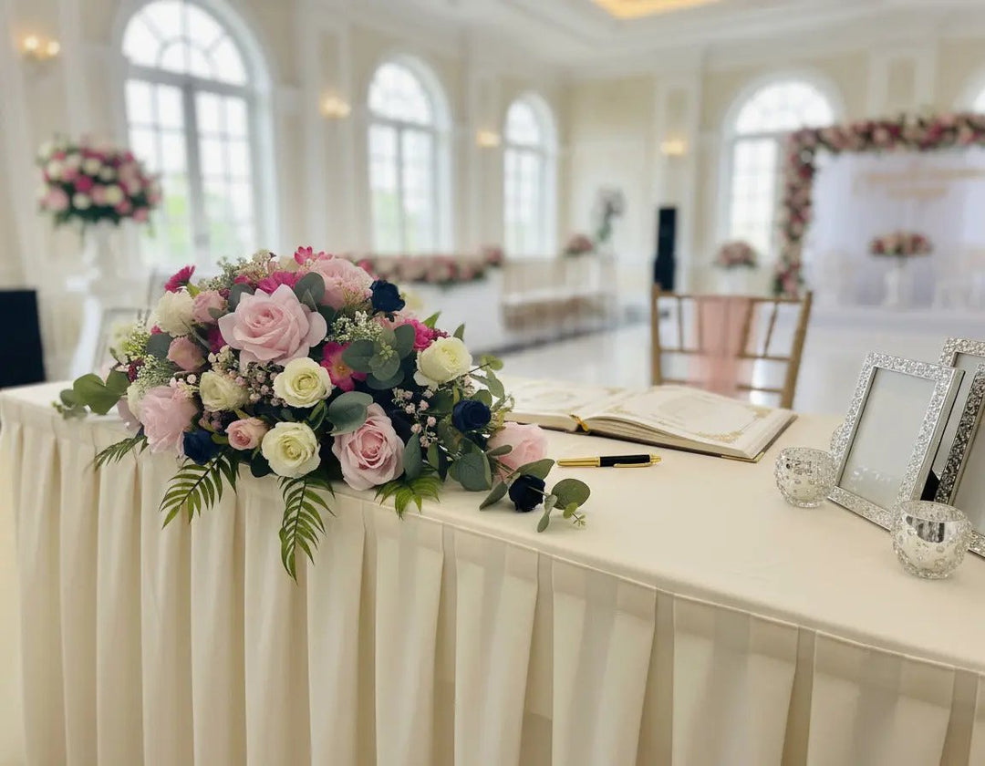 Floral arrangement with pink, white, and green flowers on a light blue background