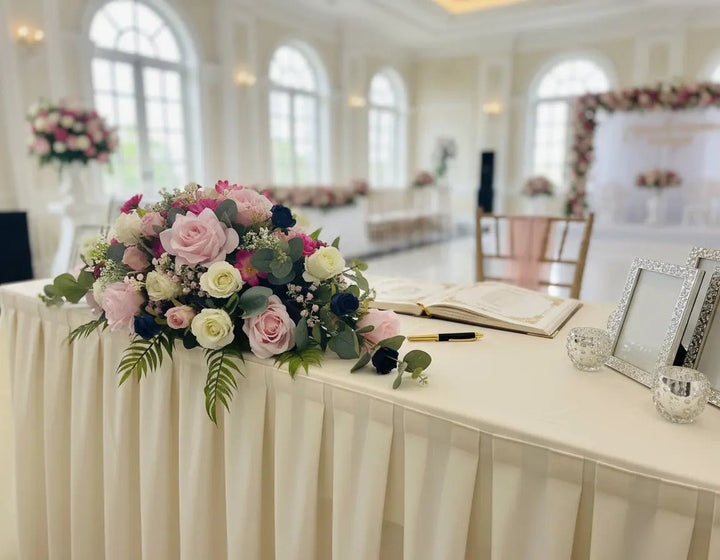 Floral arrangement with pink, white, and green flowers on a light blue background